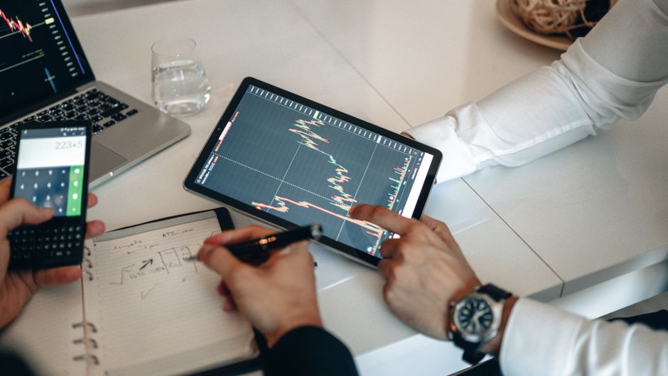 Tim radi na financijskoj analizi uz tablet i kalkulator u uredu